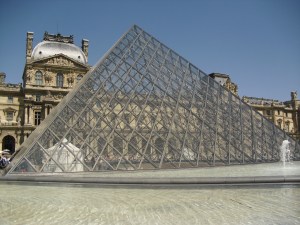 The entrance to the Louvre, surrounding by many fountains.
